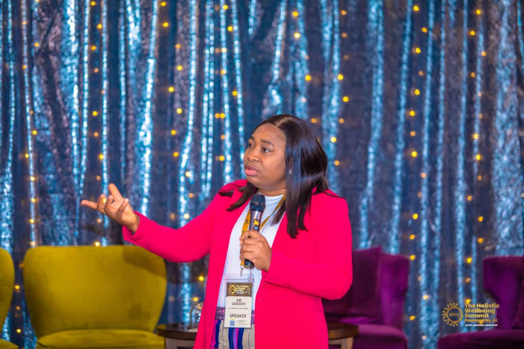 Abi Odedeyi speaking on stage to a live audience